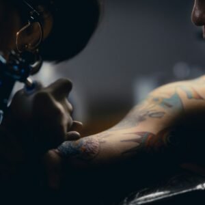a man getting a tattoo on his arm