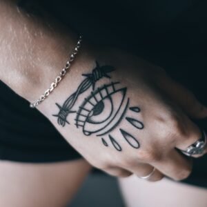 person with black tattoo on wrist